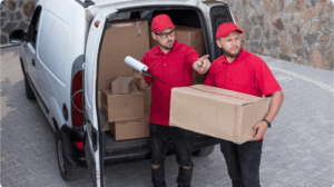 Professional couriers loading cardboard boxes into a delivery van for house relocation